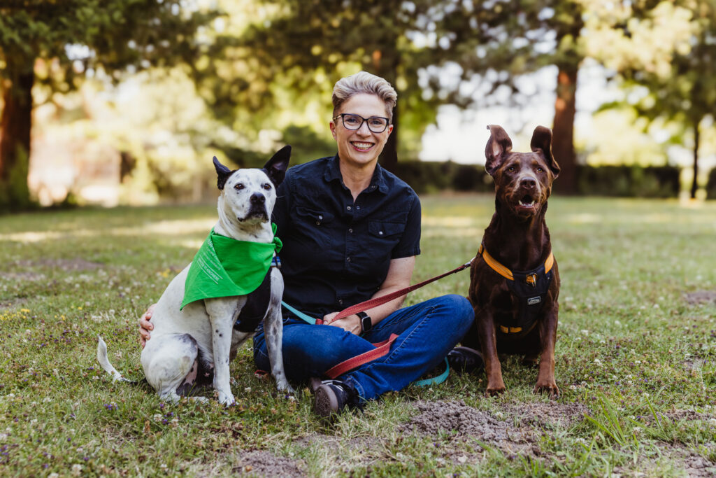 Cynthia King, outgoing CEO of Sonoma CAN, sitting outdoors with her two dogs